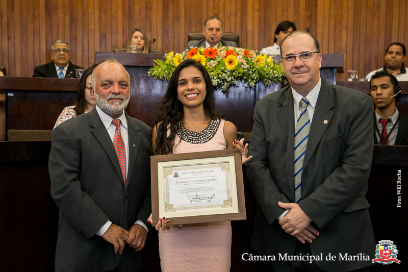 Vereadores Cícero do Ceasa e Marcos Custódio entregam homenagem a presidente do Rotaract Marília Pioneiro, Jéssica Firmino.